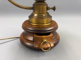 une lampe à l'ancienne posée sur un pied en bois
