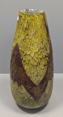 un vase jaune orné de motifs marron, posé sur une table