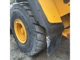 the front end of a yellow tractor with a large tire