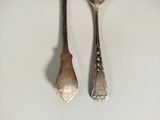 two spoons and a fork on a white surface