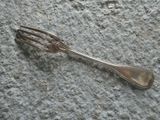 a silver spoon and fork laying on the ground