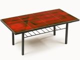 une image représentant une table rouge avec des pieds noirs et un plateau rouge