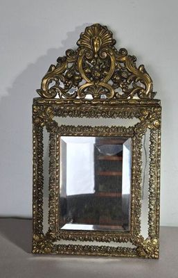 un petit miroir posé sur une table devant un mur blanc