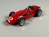 a red model of a racing car on a white surface