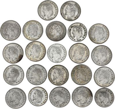 a pile of old silver coins on a white background