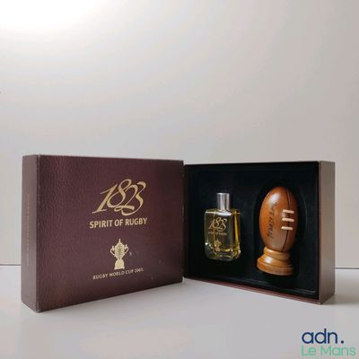 un flacon de parfum dans un coffret orné d'un ballon de football