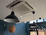 two lamps hanging from the ceiling above a table
