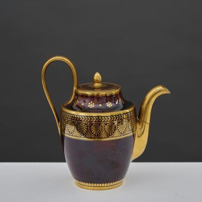 an image of a purple and gold teapot on a white table