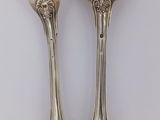 pair of silver plated forks and spoons on a white surface