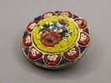 a yellow and red broochee with flowers on it