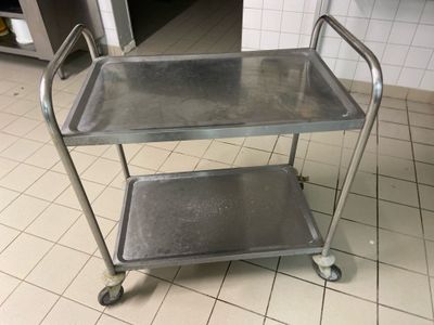 a metal cart with two trays on it in a kitchen