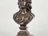 a bronze bust of a woman on a wooden base