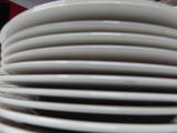 several white plates stacked on top of each other on a table