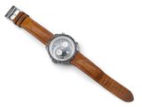 a close up of a watch on a white surface with a brown strap