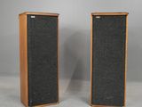 a pair of vintage speakers with wood and black fabric