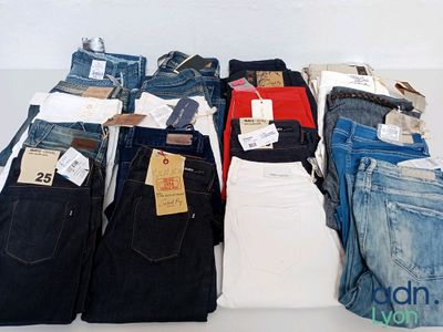 a lot of jeans that are stacked together on a table