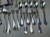 a lot of silver spoons and spoons on the table
