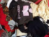 a pile of clothes that is sitting on a bed