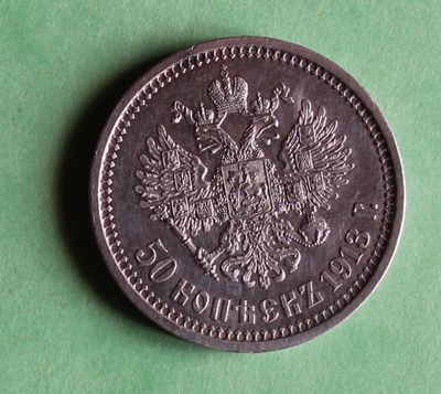 a silver coin with an eagle on it on a green surface