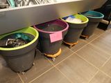 many buckets of garbage sitting on the floor in a store