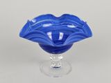 une image représentant un bol en verre bleu posé sur un socle transparent
