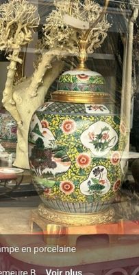 un vase posé sur une table devant une fenêtre