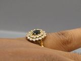 an image of a woman ' s hand with a gold ring with a black stone