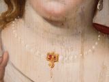 an old painting of a woman with red hair and a gold broocher on her neck