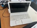 a white laptop computer sitting on a desk with a black bag