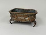 an old metal planter with a bird design on it