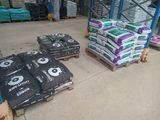 many bags of cement sitting on pallets in a warehouse