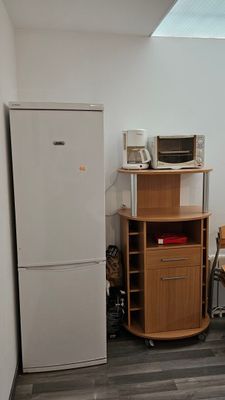 une photo d'une cuisine avec un réfrigérateur et un micro-ondes