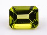 a green tourmaline gemstone on a white surface