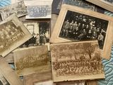 a lot of old photographs on a bed with a blue comforter