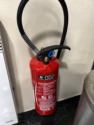 un extincteur posé sur un comptoir à côté d'une poubelle