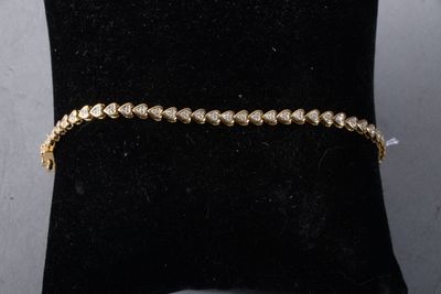 a gold bracelet on a black cushion