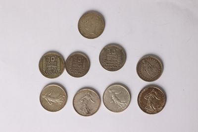 six different coins are arranged in a row on a white surface