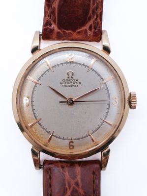 an image of a gold watch with a brown leather strap