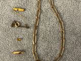 un gros plan sur un collier à chaîne en or et une paire de boucles d'oreilles