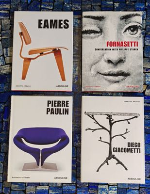 quatre livres posés sur un sol carrelé bleu, avec une chaise et une table
