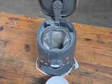 a small metal pot sitting on top of a wooden table