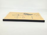 a book with a drawing of a cat on it sitting on a table