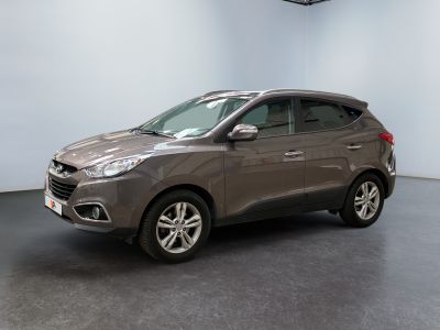the grey car is parked in a large room with a black floor