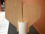a white vase that has two wooden wings on top of it