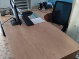 a desk with a computer and a chair in a room