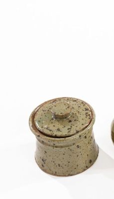 two ceramic containers sitting next to each other on a white surface