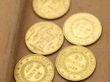 quatre pièces d'or posées sur une table, à côté d'un couteau