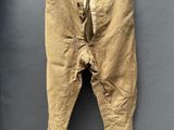 un vieux pantalon suspendu à une corde à linge fixée au mur