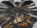 a black plate with a painting on it on a table