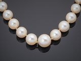 a cultured pearl necklace on a black background